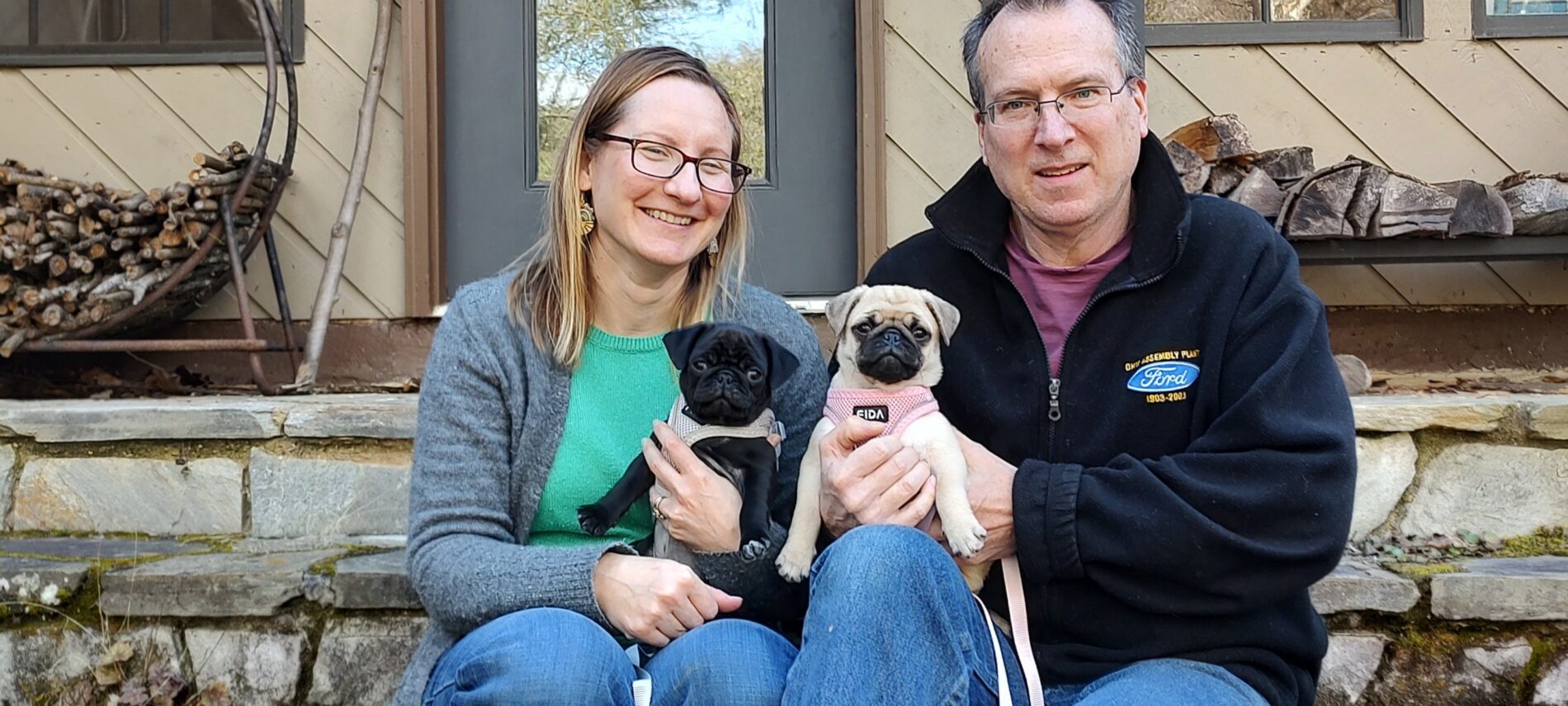 Brigette and Dave sitting on stone stairs at the Inn on Mill Creek Bed & Breakfast with the innpugs, Chibi and Honey