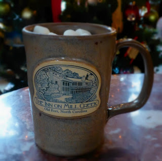 Sand colored Inn on Mill Creek logo mug filled with hot cocoa and marshmallows