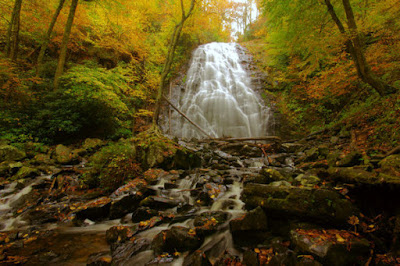 Beautiful cascading waterfall that ends in a rocky creek in the woods