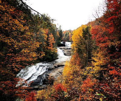 Set of three cascading waterfalls in a rocky and woodsy landscape