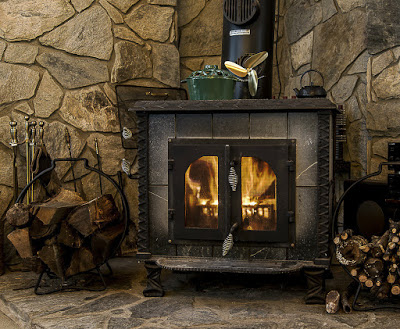 Crackling fire in wood stove with stone hearth