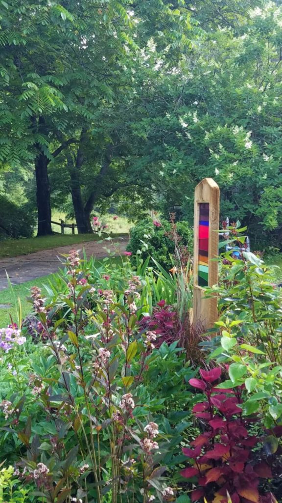 Multi-colored stained glass framed in wood in a garden