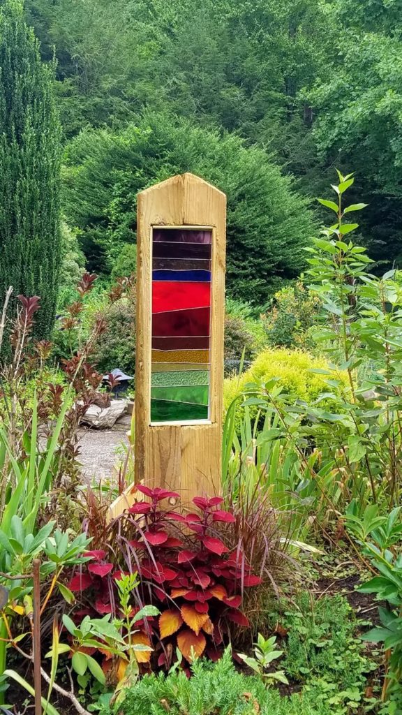 Multi-colored stained glass framed in wood in a garden