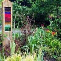 Multi-colored stained glass framed in wood in a garden