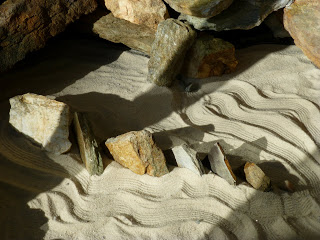 Seven stones arranged in a small zen garden in the form of the Seven Sisters Range in Black Mountain