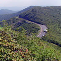 Road curving through tree-filled mountain ridges