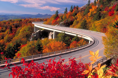 Road curving around a mountain full of brilliant fall foliage