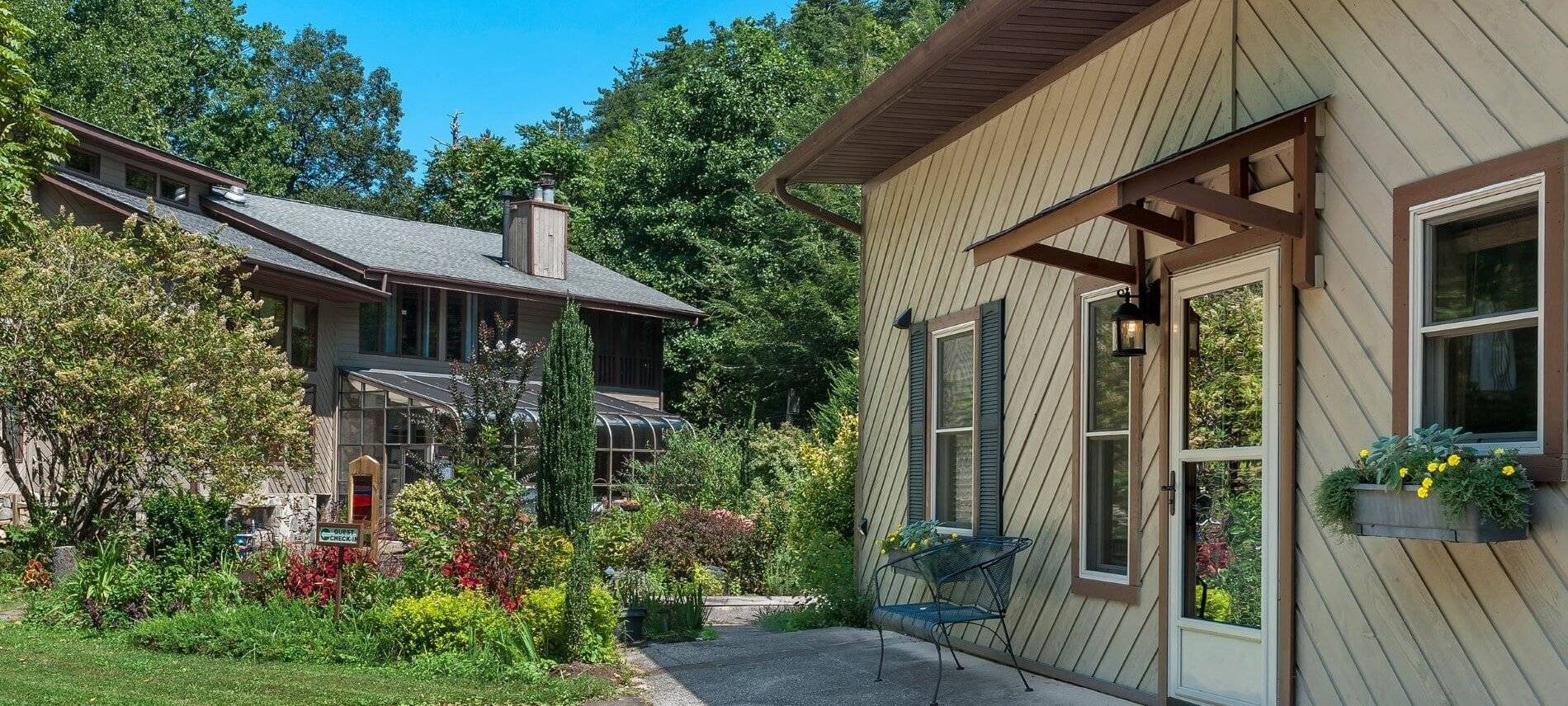 garden in between main house with sunroom and side-view of cottage